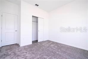 1163 James Paul Rd, Davenport, FL 33837 - unfurnished bedroom with carpet, a closet, and baseboards