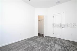 1163 James Paul Rd, Davenport, FL 33837 - unfurnished bedroom with dark carpet and baseboards