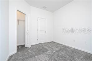 1163 James Paul Rd, Davenport, FL 33837 - unfurnished bedroom featuring carpet and baseboards