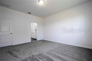 1163 James Paul Rd, Davenport, FL 33837 - unfurnished bedroom with baseboards and carpet flooring