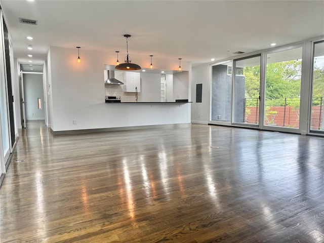 unfurnished living room featuring baseboards, visible vents, electric panel, and dark wood-style floors
