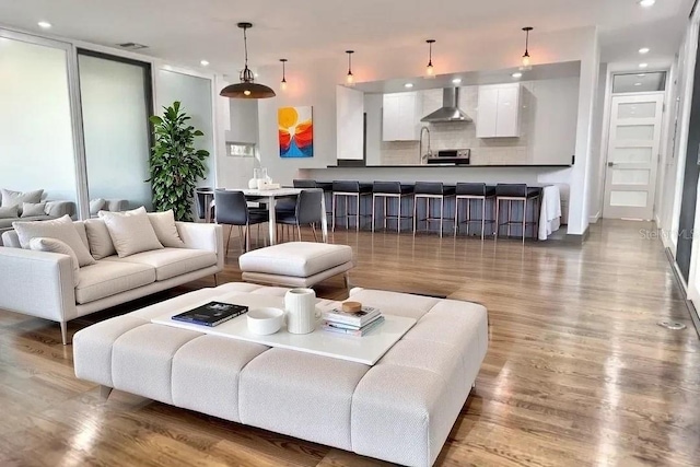 living area featuring wood finished floors, visible vents, and recessed lighting