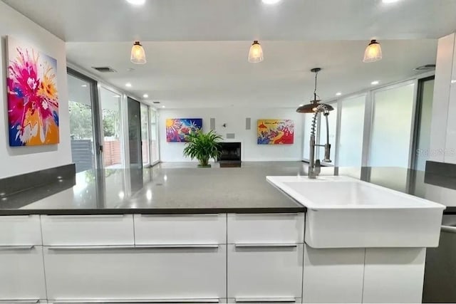 kitchen with white cabinets, visible vents, recessed lighting, and a sink