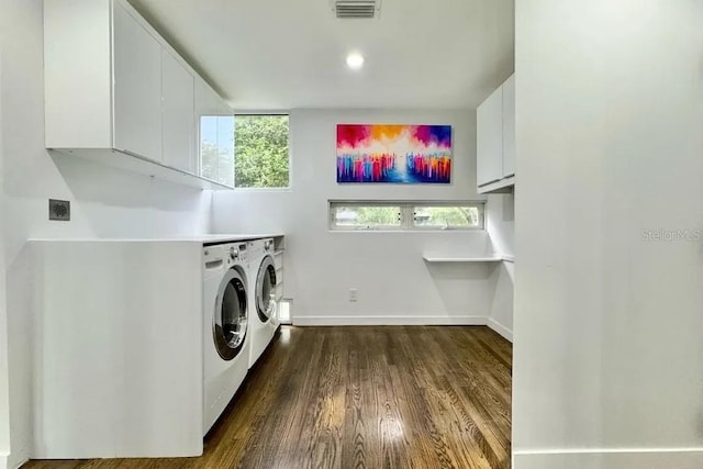 laundry area with washer and clothes dryer, cabinet space, dark wood finished floors, baseboards, and visible vents