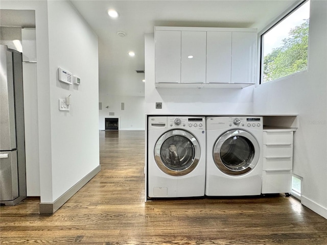 washroom with washing machine and dryer, baseboards, recessed lighting, cabinet space, and wood finished floors