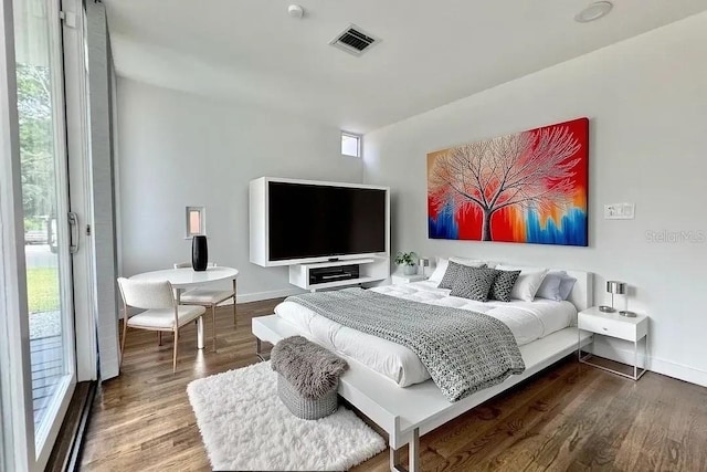 bedroom with baseboards, visible vents, wood finished floors, and access to outside