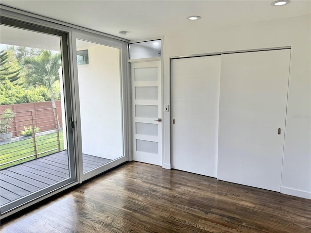 unfurnished bedroom featuring dark wood-style floors, access to outside, and recessed lighting