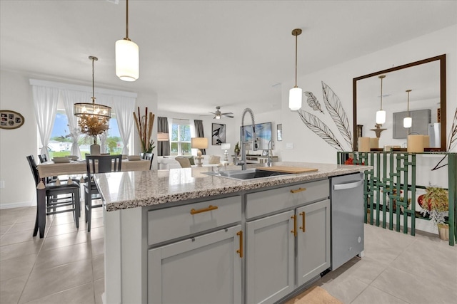 kitchen featuring dishwasher, a sink, a center island with sink, and light tile patterned floors