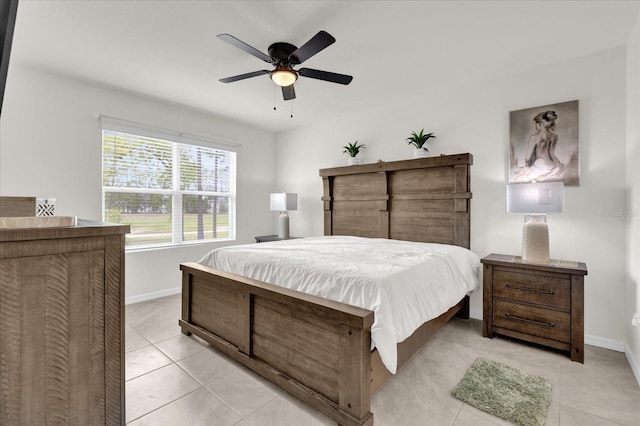 bedroom with a ceiling fan, baseboards, and light tile patterned flooring