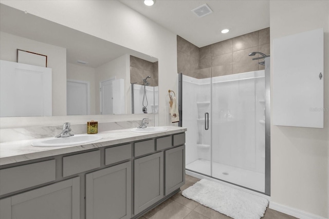 full bathroom featuring double vanity, visible vents, a stall shower, and a sink
