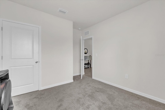 unfurnished bedroom featuring baseboards, carpet flooring, and visible vents