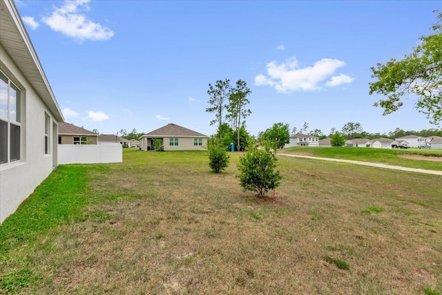 view of yard featuring fence and a residential view