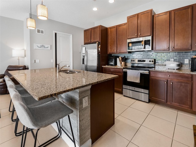 193 Captiva Dr, Davenport, FL 33896 - kitchen with a breakfast bar area, visible vents, tasteful backsplash, a sink, and stainless steel appliances