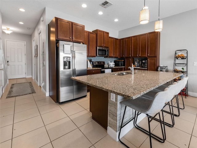 193 Captiva Dr, Davenport, FL 33896 - kitchen featuring a breakfast bar area, stainless steel appliances, visible vents, and light stone counters