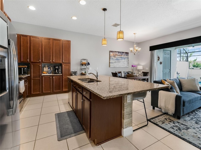 193 Captiva Dr, Davenport, FL 33896 - kitchen featuring a breakfast bar area, light stone countertops, a sink, light tile patterned floors, and stainless steel appliances