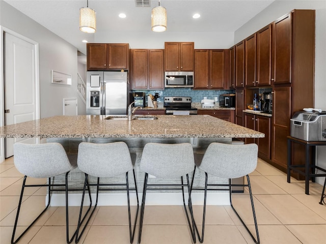 193 Captiva Dr, Davenport, FL 33896 - kitchen with a sink, appliances with stainless steel finishes, decorative light fixtures, and a kitchen breakfast bar