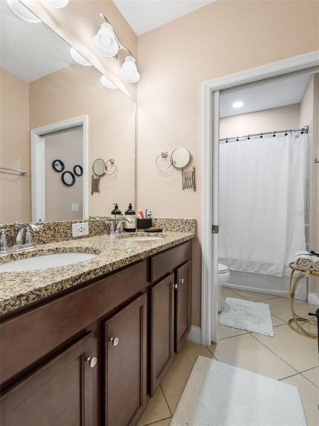193 Captiva Dr, Davenport, FL 33896 - full bath featuring double vanity, shower / bath combination with curtain, a sink, tile patterned floors, and toilet