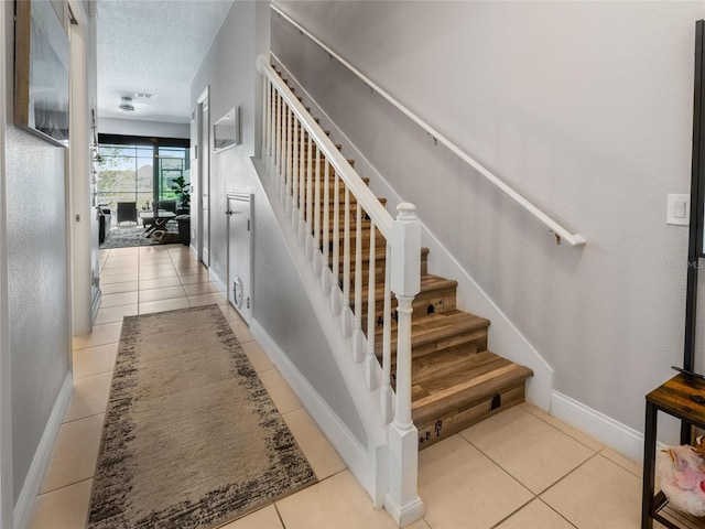 193 Captiva Dr, Davenport, FL 33896 - stairs featuring baseboards, tile patterned flooring, and a textured ceiling