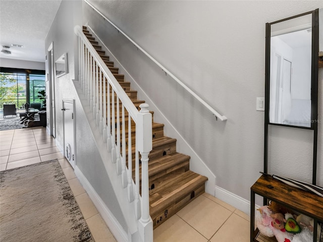 193 Captiva Dr, Davenport, FL 33896 - staircase with tile patterned flooring, a textured ceiling, and baseboards