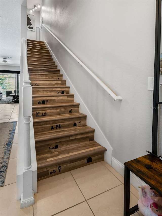 193 Captiva Dr, Davenport, FL 33896 - staircase featuring a textured ceiling, tile patterned floors, and baseboards