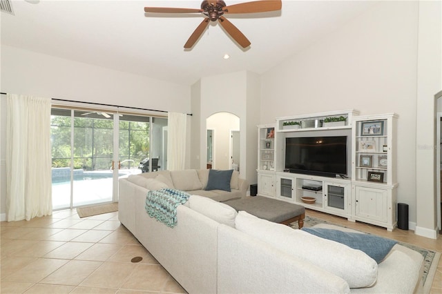 living room with visible vents, ceiling fan, arched walkways, light tile patterned flooring, and high vaulted ceiling