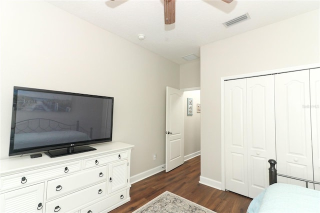 bedroom featuring dark wood-style floors, a closet, ceiling fan, visible vents, and baseboards