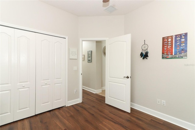 unfurnished bedroom with dark wood-style floors, visible vents, and baseboards