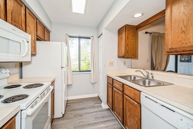 150 Waterfall Way Unit 102, Altamonte Springs, FL 32714 - kitchen featuring brown cabinets, a sink, light countertops, light wood-type flooring, and white appliances
