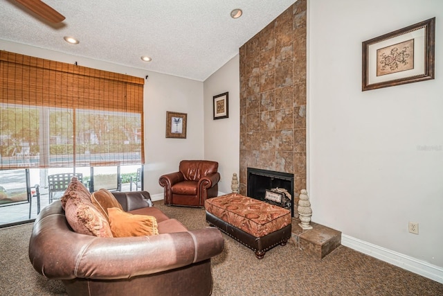 150 Waterfall Way Unit 102, Altamonte Springs, FL 32714 - living room featuring a textured ceiling, a tiled fireplace, carpet, and baseboards