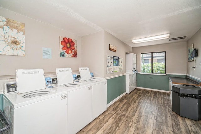 150 Waterfall Way Unit 102, Altamonte Springs, FL 32714 - community laundry room featuring wood finished floors, stacked washer and dryer, washer and dryer, baseboards, and visible vents