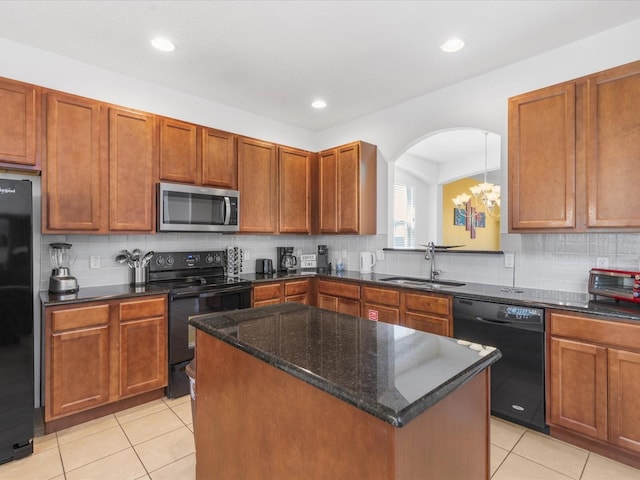 411 Cabello Dr, Davenport, FL 33837 - kitchen with a sink, a center island, light tile patterned floors, tasteful backsplash, and black appliances