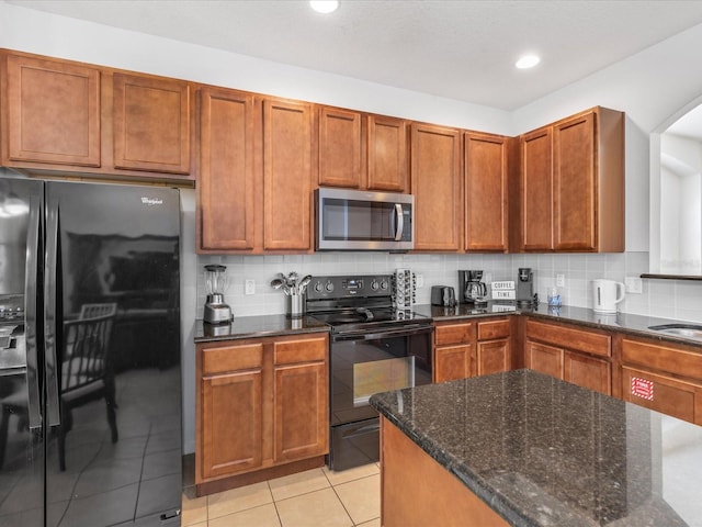 411 Cabello Dr, Davenport, FL 33837 - kitchen with recessed lighting, dark stone countertops, backsplash, light tile patterned floors, and black appliances