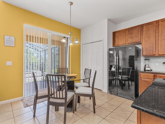 411 Cabello Dr, Davenport, FL 33837 - dining space with light tile patterned flooring, baseboards, and an inviting chandelier
