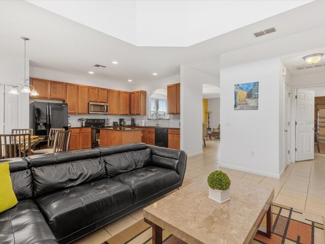 411 Cabello Dr, Davenport, FL 33837 - living room with arched walkways, recessed lighting, baseboards, light tile patterned floors, and visible vents