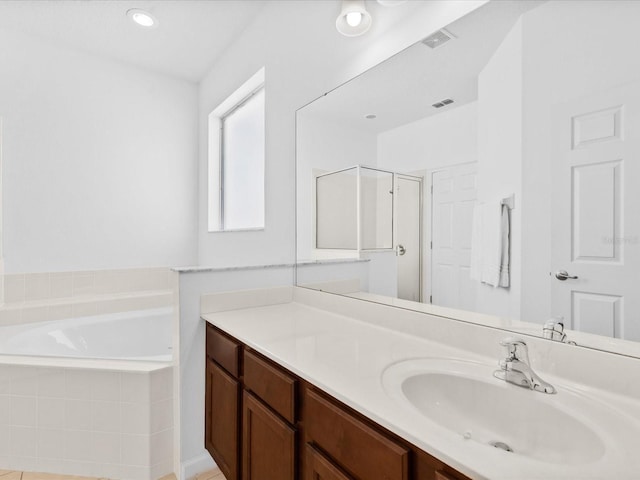 411 Cabello Dr, Davenport, FL 33837 - full bath with vanity, a bath, visible vents, and a shower stall