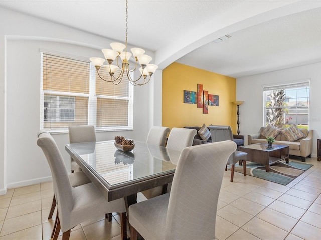 411 Cabello Dr, Davenport, FL 33837 - dining room with arched walkways, a chandelier, baseboards, light tile patterned floors, and visible vents