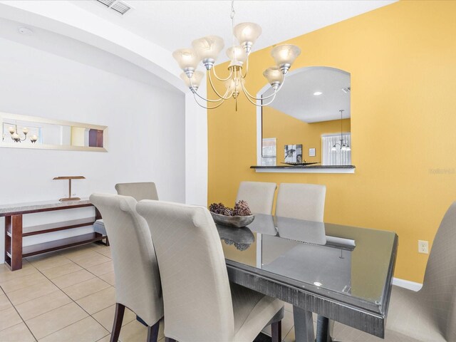 411 Cabello Dr, Davenport, FL 33837 - tiled dining space featuring visible vents, arched walkways, baseboards, and a chandelier
