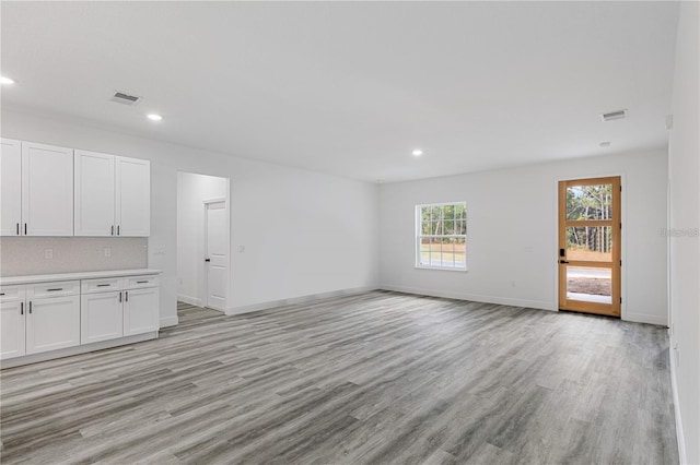 unfurnished living room featuring visible vents, light wood-style flooring, and recessed lighting