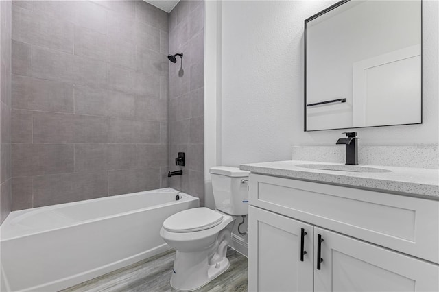 full bath featuring wood finished floors, toilet, tub / shower combination, and vanity