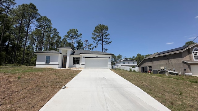 view of front of home with a front yard, driveway, an attached garage, and stucco siding