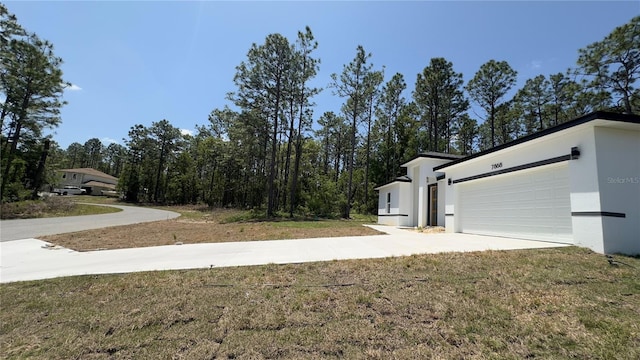 view of yard with concrete driveway and an attached garage