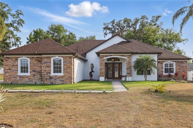 view of front facade with stone siding, roof with shingles, stucco siding, french doors, and a front lawn