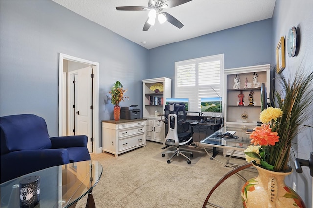 home office featuring a ceiling fan and light carpet