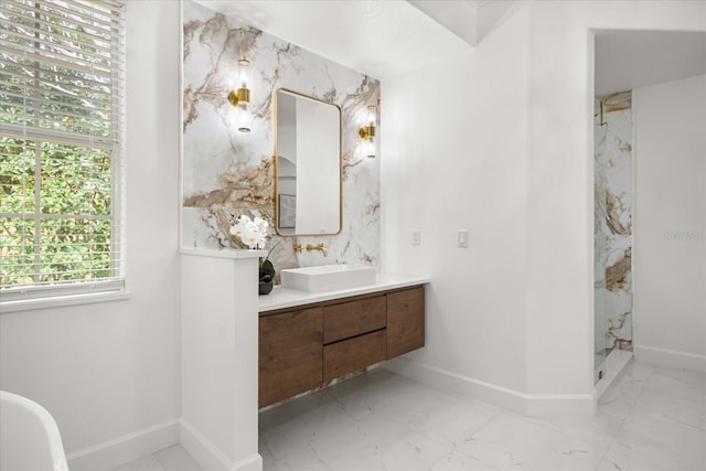 full bathroom with marble finish flooring, a marble finish shower, vanity, and baseboards
