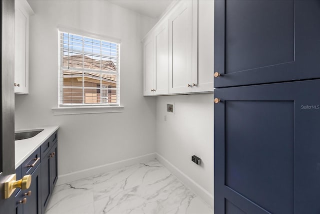 clothes washing area with cabinet space, washer hookup, baseboards, and light marble finish flooring