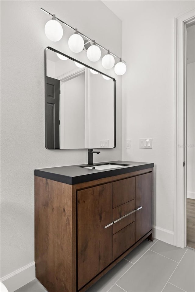 bathroom featuring baseboards, vanity, and tile patterned flooring