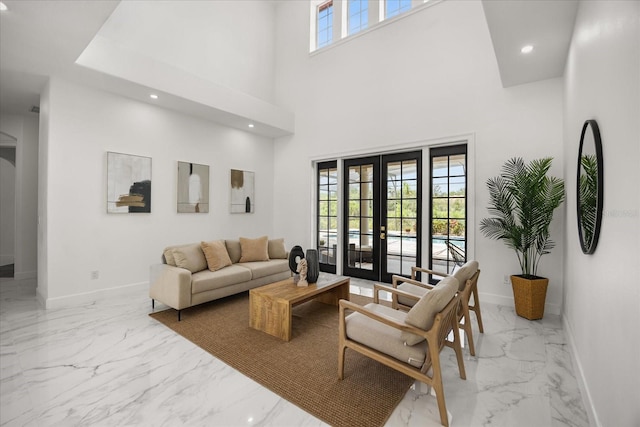 living room with marble tiled floors, baseboards, recessed lighting, french doors, and a towering ceiling