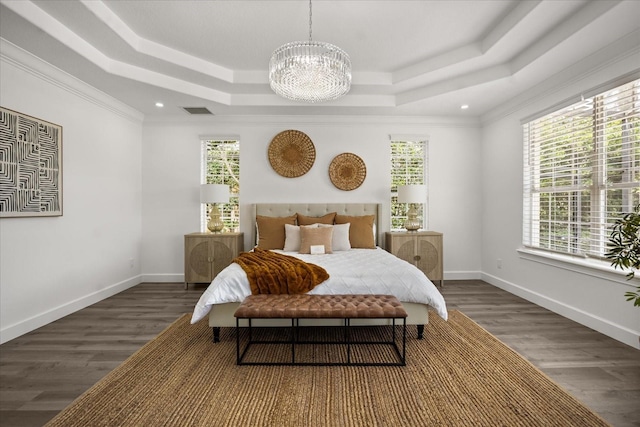 bedroom with a raised ceiling, multiple windows, a chandelier, wood finished floors, and recessed lighting
