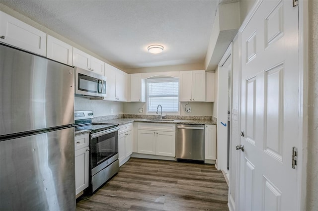 72 Campus View Dr, Orlando, FL 32810 - kitchen featuring a sink, appliances with stainless steel finishes, white cabinetry, and dark wood-type flooring