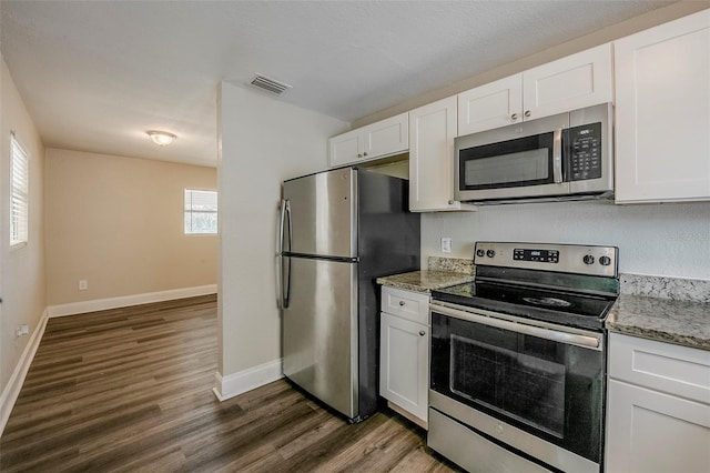 72 Campus View Dr, Orlando, FL 32810 - kitchen featuring stainless steel appliances, dark wood finished floors, white cabinetry, and visible vents